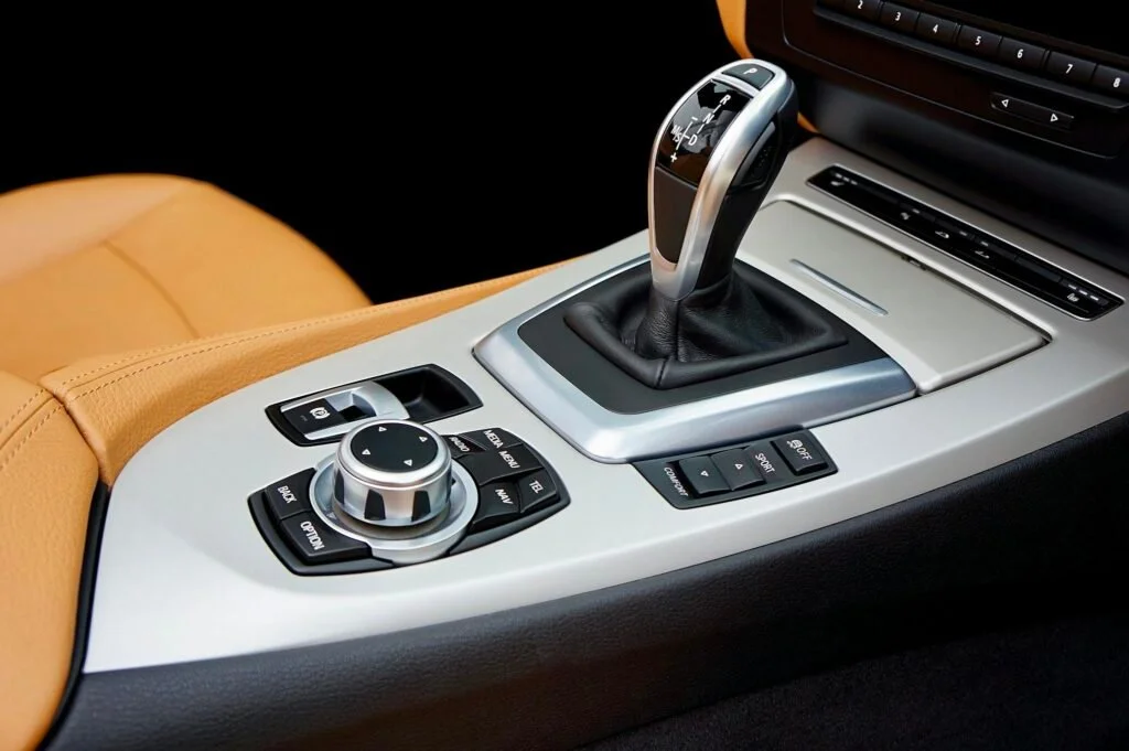 Close-up of a luxury car's interior with a focus on the modern gear shift and control panel.